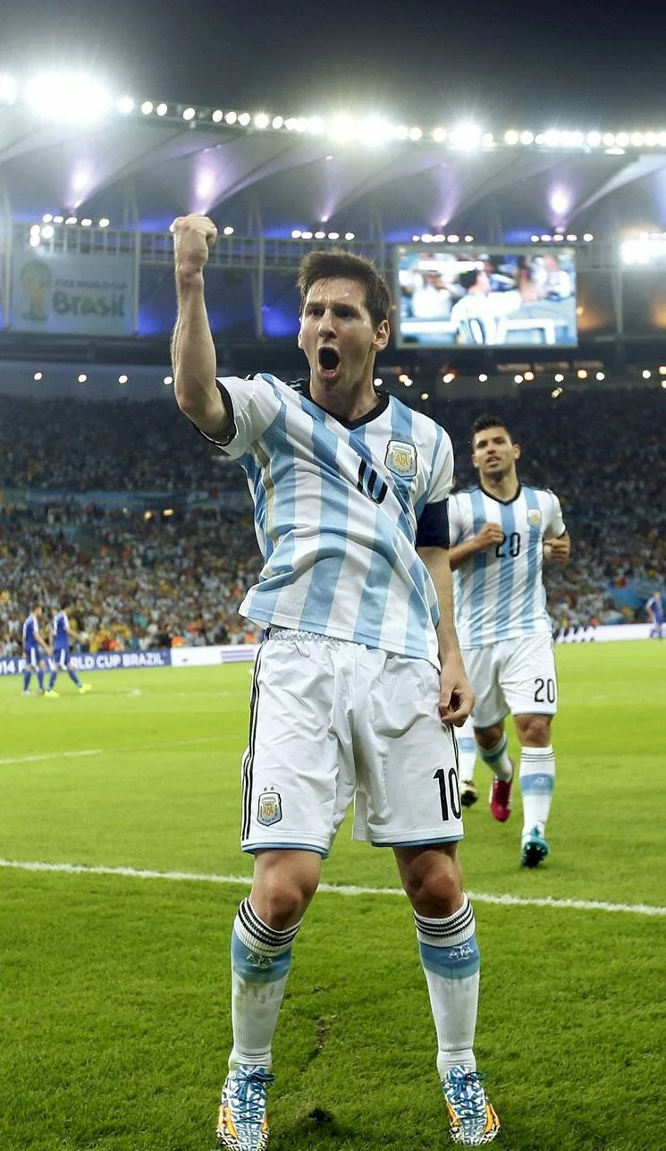Ảnh bóng đá Lionel Messi giơ nắm đấm ăn mừng trong màu áo đội tuyển Argentina tại sân vận động
