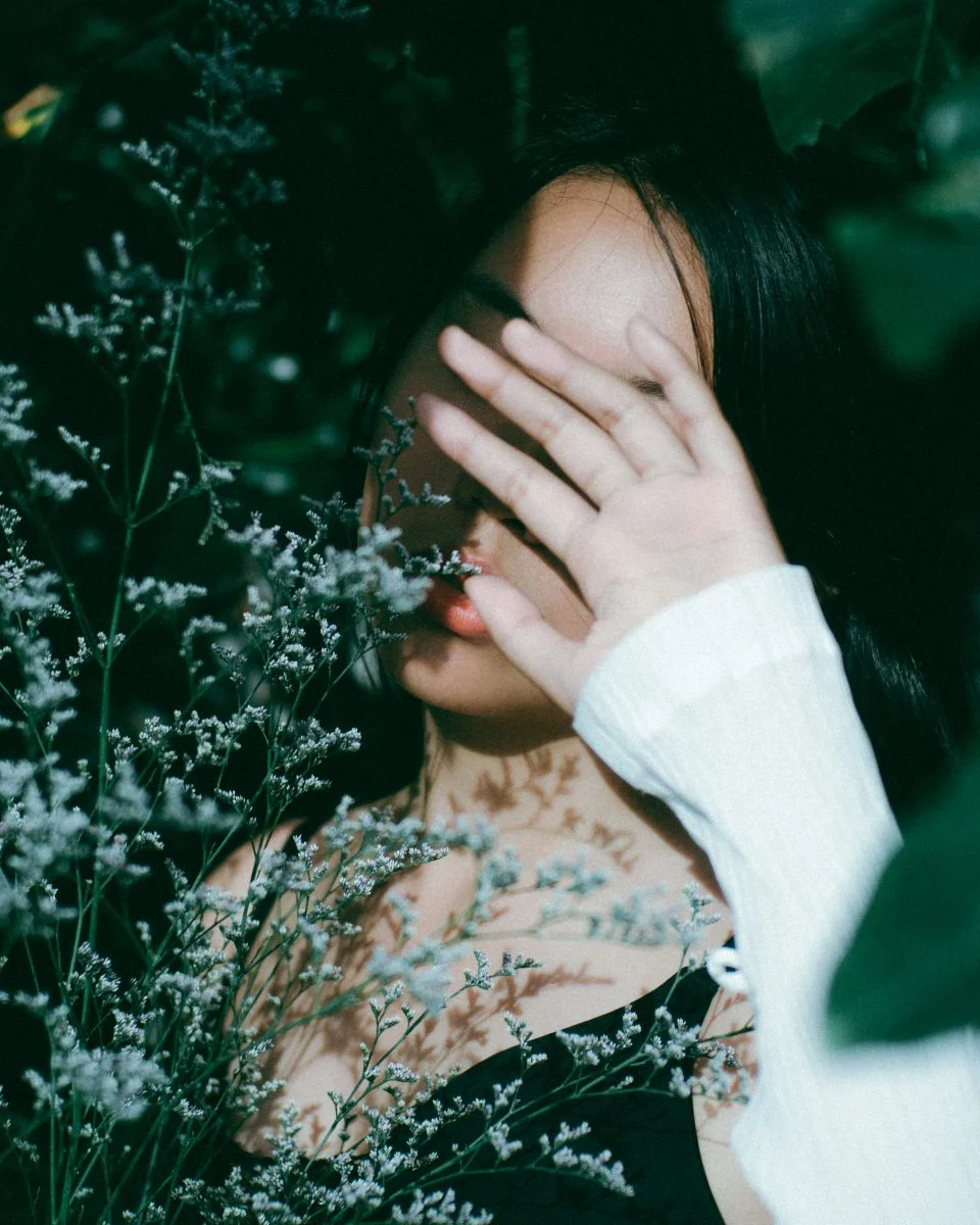 Cô gái che mặt giữa những cành hoa trắng, gợi cảm giác e ấp và tâm trạng mong manh