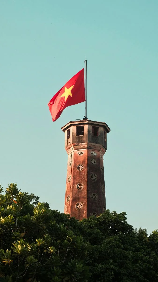Lá cờ Việt Nam trên tháp cao giữa tán cây xanh