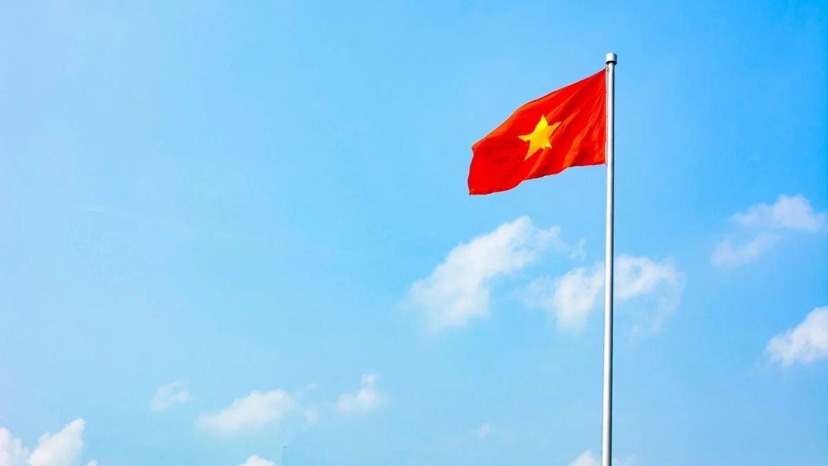 Lá cờ Việt Nam bay cao trên cột cờ giữa nền trời xanh