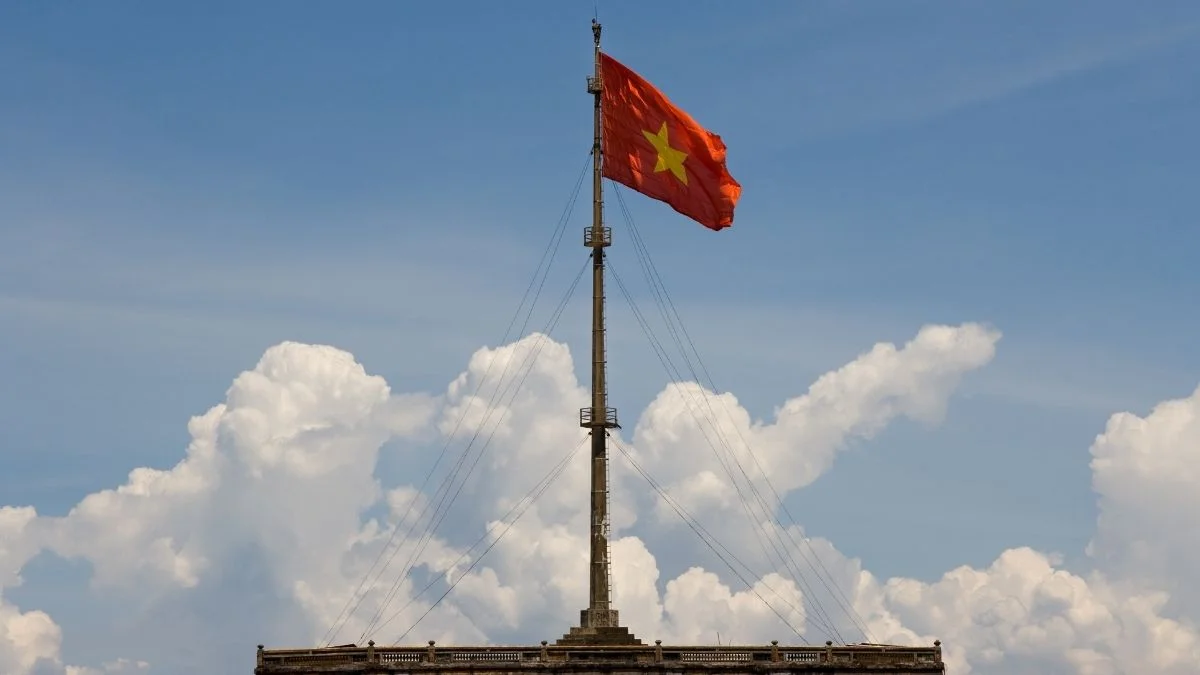 Lá cờ Việt Nam trên cột cờ cao giữa bầu trời nhiều mây